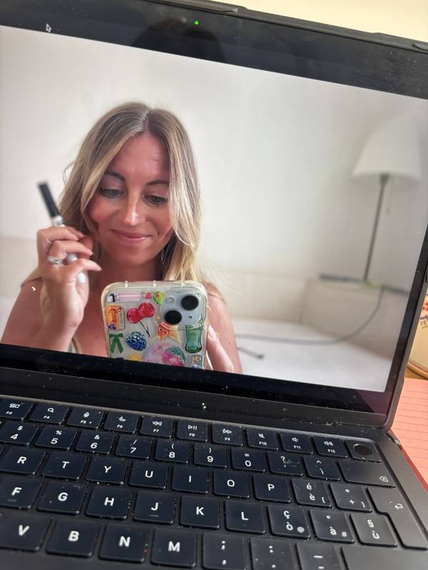 Jenn talking to her phone camera in front of her laptop